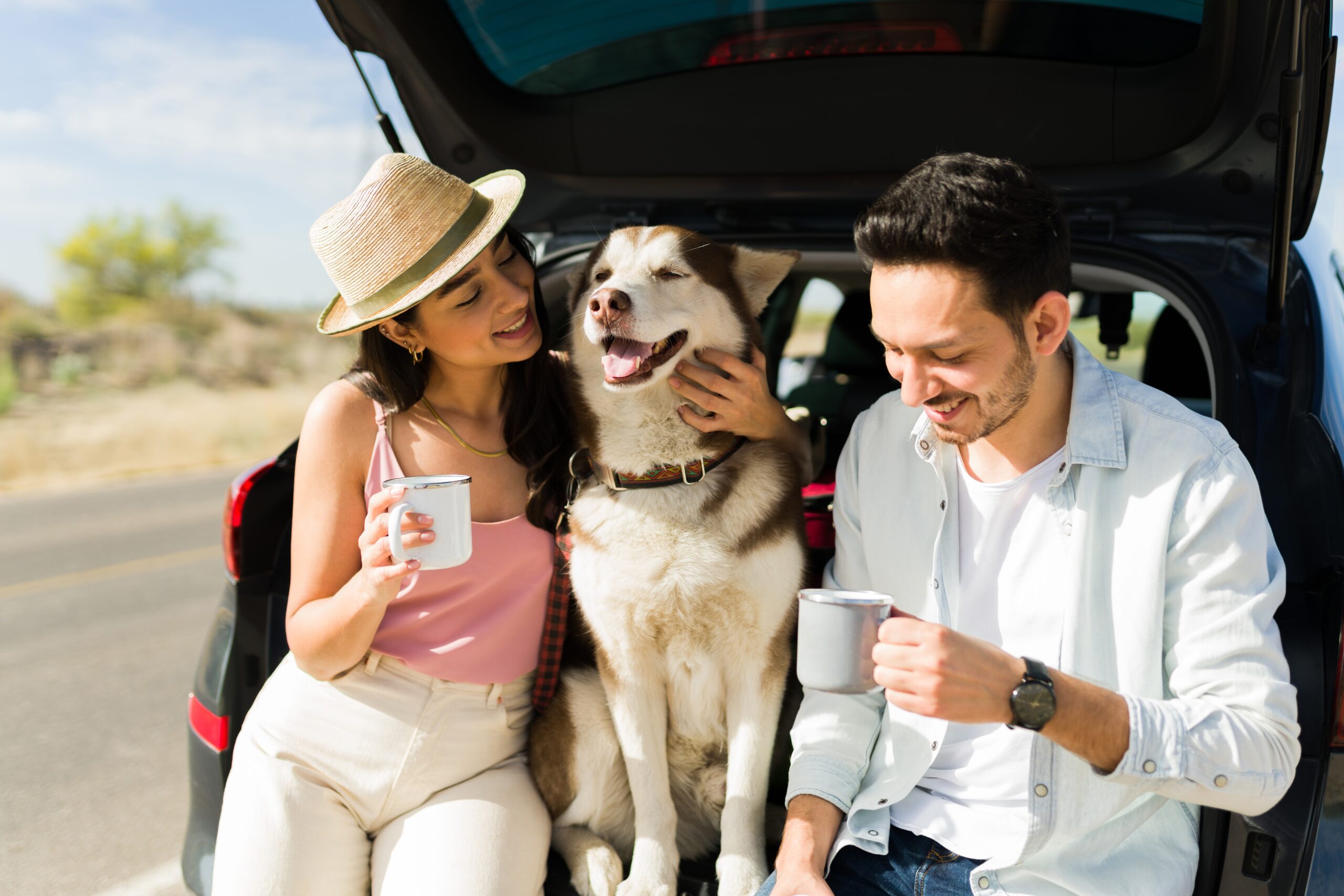Cheerful,Couple,Petting,Their,Dog,And,Drinking,Coffee,While,Taking