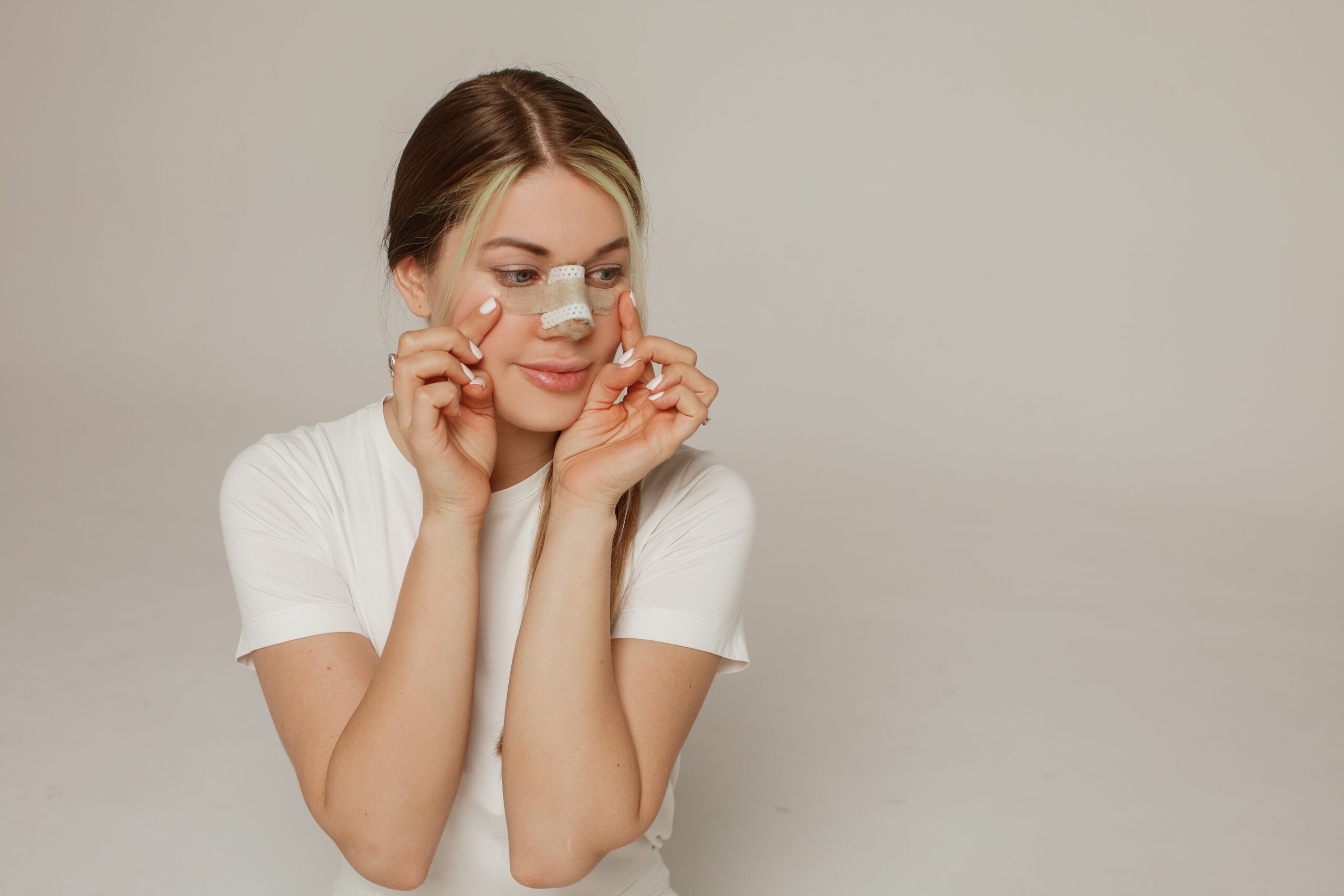 A,Young,Woman,With,A,Bandage,On,Her,Nose,After