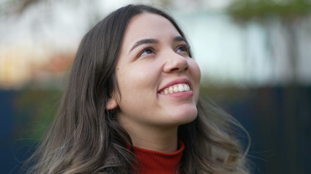 laser eye surgery on private health insurance. Young woman looks towards the sky with a hopeful look on her face.