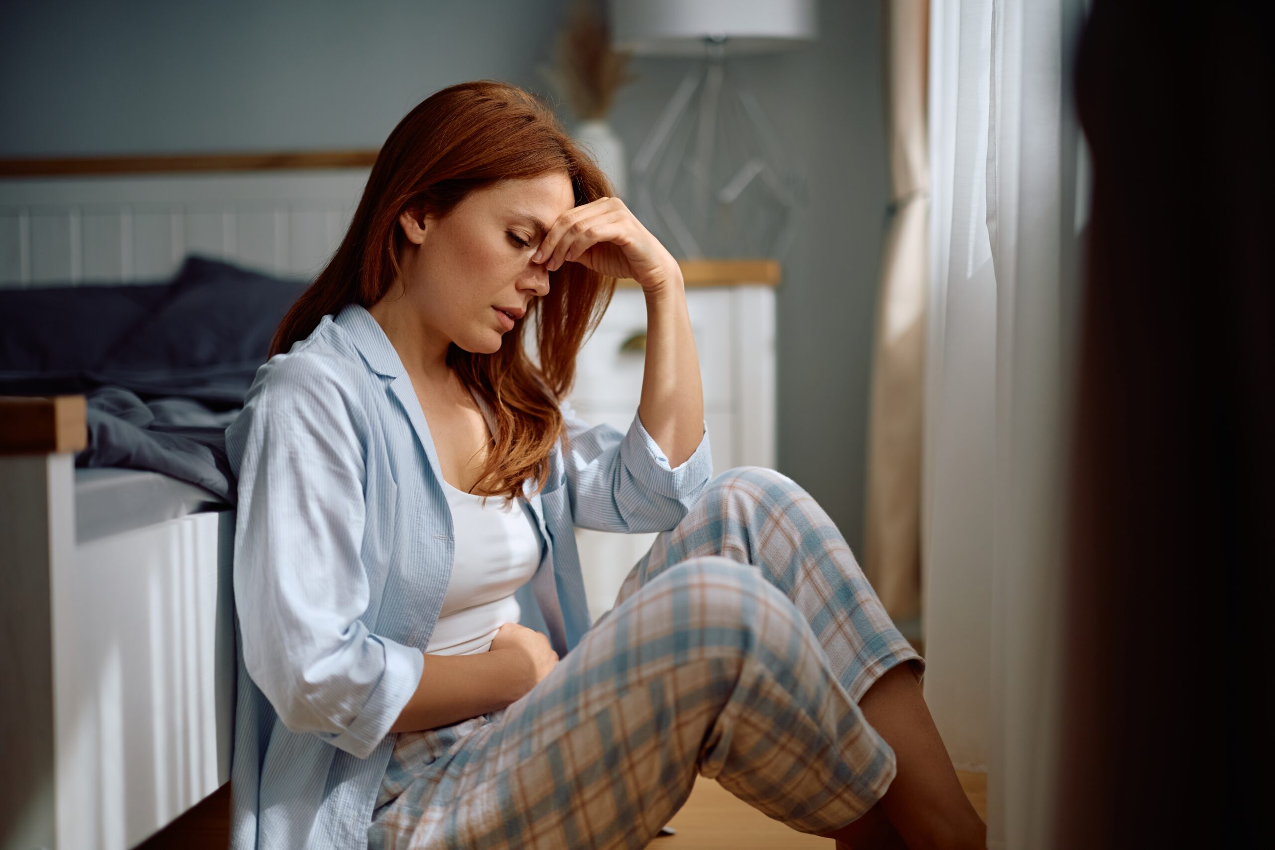 Distraught,Woman,Holding,Her,Abdomen,In,Pain,While,Sitting,On